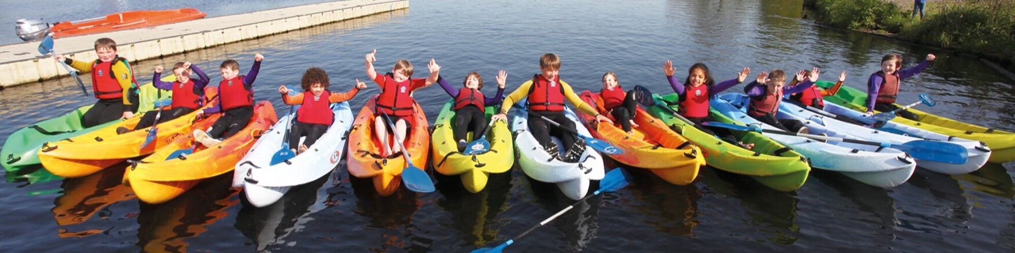 Twelve children in water equipment on body of water