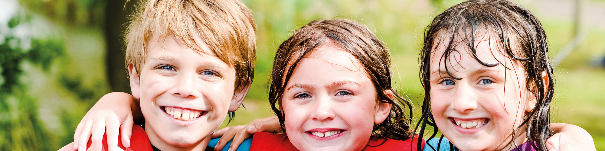 Three children hugging and smiling