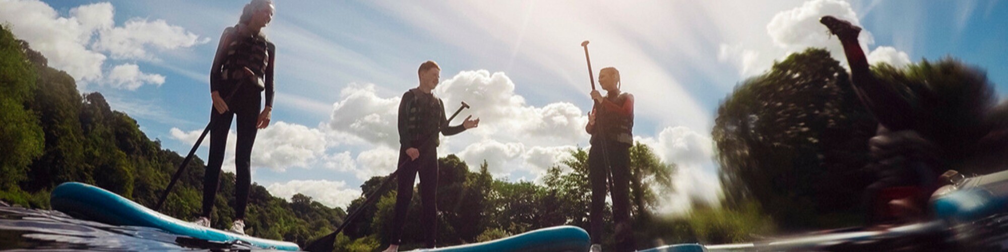 Three people on hired stand up paddleboards