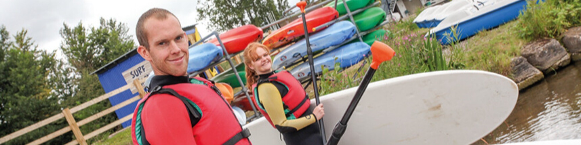 Two Adults launching their own Stand Up Paddleboards